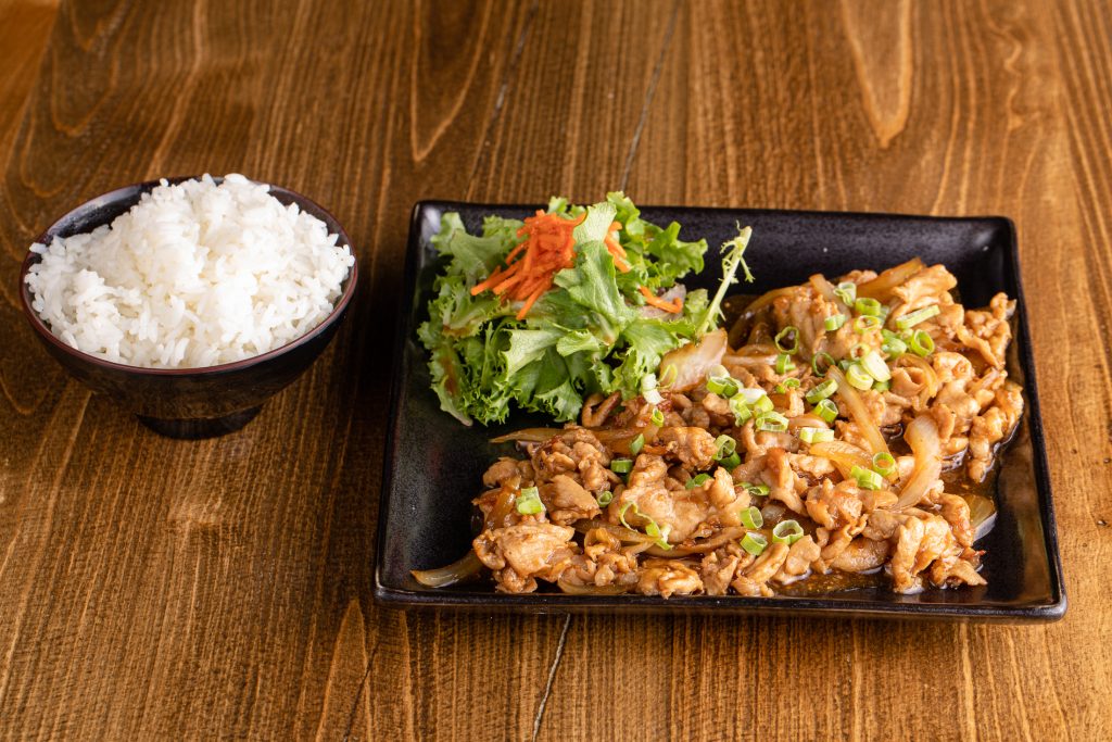 Thinly sliced pork, sautéed with onion and ginger sauce, a side of rice and a salad