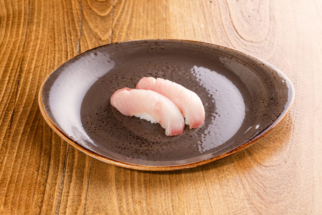 Two yellowtail nigiri on a plate