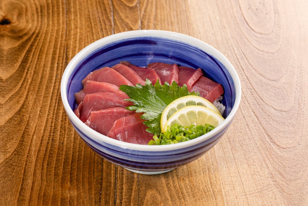 Slices of raw tuna over sushi rice