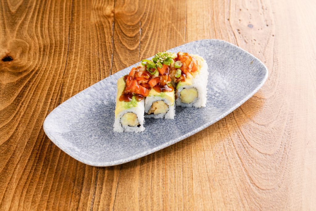 Tempura vegetable roll with special sauce, avocado, sesame seeds, green onion